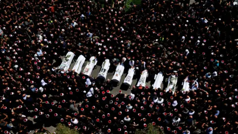 Reuters Mourners surround 10 coffins of children killed in strike