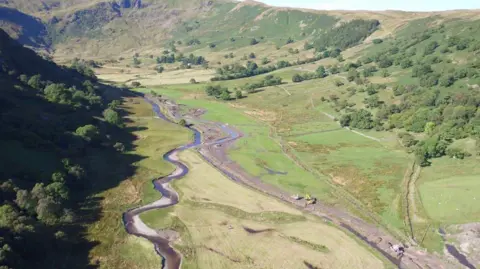 Environment Agency An aerial view of two streams of water down a rural valley. Diggers are working on one stream, the other meanders through the fields.