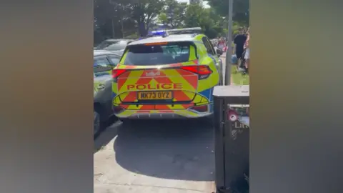 Julie Swift A police car struggles to pass parked cars on a gridlocked road in Formby.