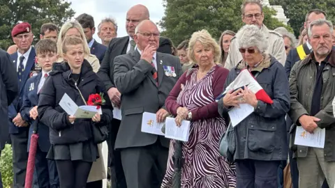 BBC/Olivia Richwald A crowd of mourners at a funeral