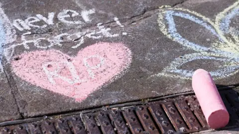 Reuters A chalk heart is drawn on a pavement, alongside the message 'Never forget, RIP' and a picture of a flower