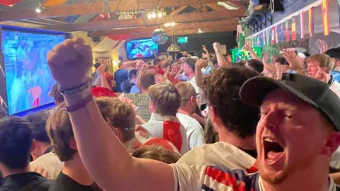 Football fans at The Old Lane pub celebrating England's win.