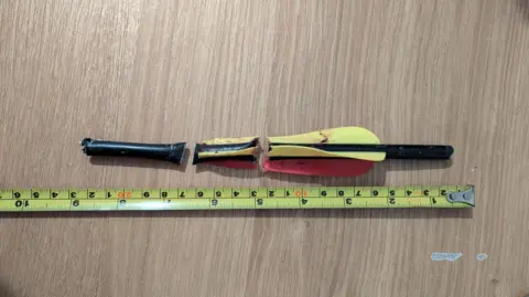 RSPCA The red and yellow bolt, cut into three sections after being removed from the dog.  It has a measure next to it, that shows the bow was about 9 inches long.