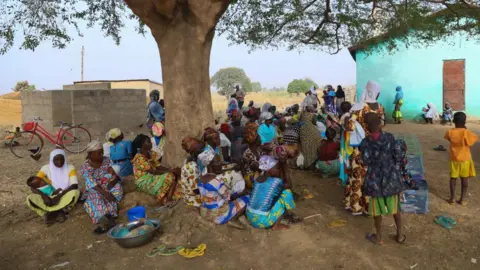 Wanita AFP berkumpul di bawah pohon di pemukiman pengungsi di Issakateng-Bausi, di Bawku, Ghana utara, pada 7 Desember 2022