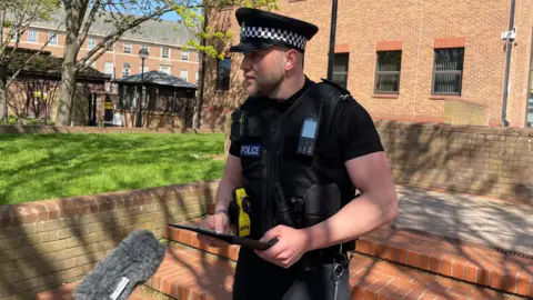 Insp Ben Wildman wearing police uniform stood outdside of Derby Crown Court