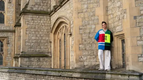 Jade Franks Franks in a colourful top, in front of university buildings