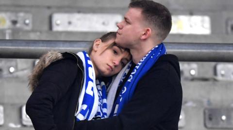 A female Schalke fans is consoled after their defeat