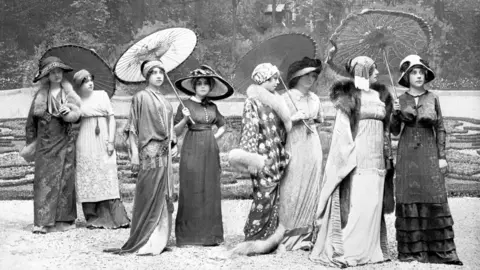 Jean Sebastien Baschet L'Illustration Image of eight models in 1910 wearing gowns and holding parasols