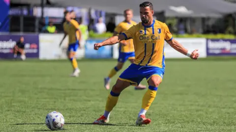 Mansfield Town Football Club Mansfield Town player about to kick a ball during a match