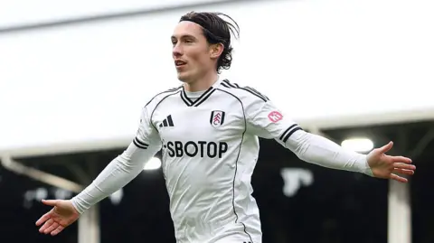 Harry Wilson celebrates a goal for Fulham with his arms outstretched