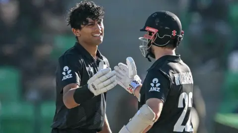 New Zealand batters Rachin Ravindra (left) and Kane Williamson (right) clasps hands after Ravindra reaches his century