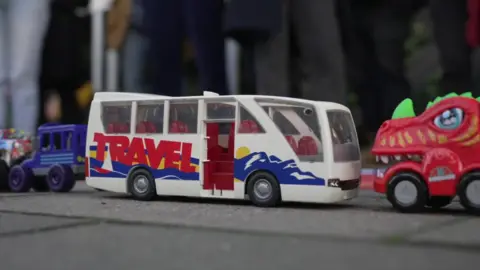 A toy bus placed on the pavement as part of the protest against planned changes to secondary school provision in Brighton and Hove.