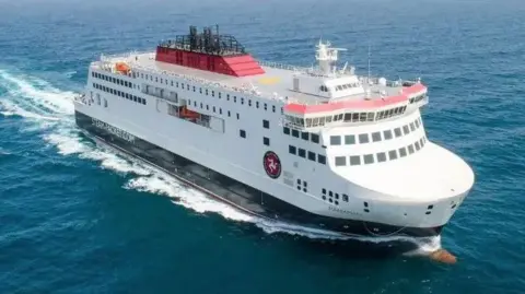 IOMSPC The Manxman ferry sailing on the open sea. It is painted in the Isle of Man Steam Packet Company's colours of white, red and black and has the company's logo on the side at the front.