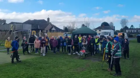 James Elliot A large group of people with spades ready to begin planting the trees