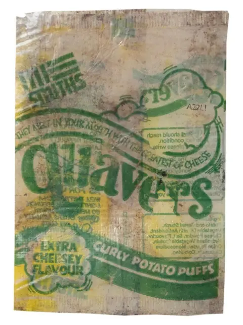 El Clarke An old and faded Quavers packet. The writing is green and above the logo, it says "They melt in your mouth with the greatest of cheese'
