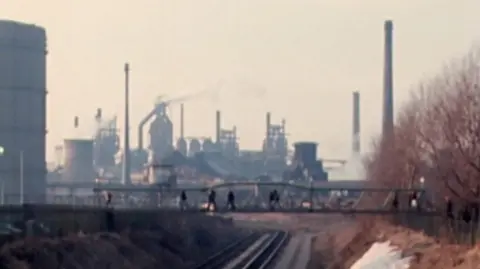 La foto de archivo muestra una vía ferroviaria que conduce a una gran planta industrial.