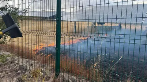 Shirebrook Fire Station Fire underneath solar panels. There is a fence at the forefront of the photo. 