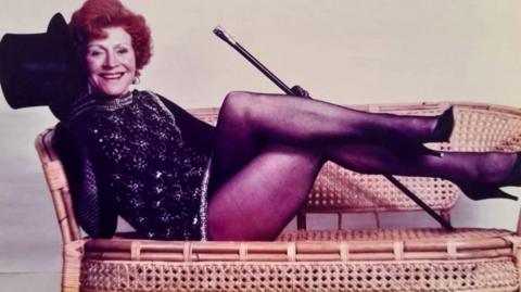 Helen Russell reclining on a sofa after performing