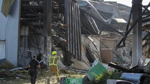 Rescuers work at the site of a shopping centre destroyed by the strike
