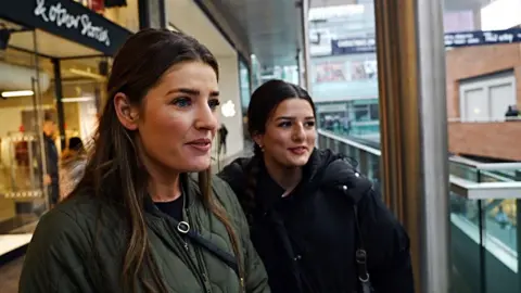 Lorna and her friend wearing jackets in Liverpool's outdoor shopping centre