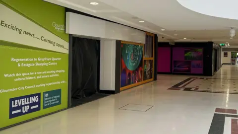 LDRS Empty shop units with regeneration branding on them inside an indoor shopping centre, where no customers can be seen