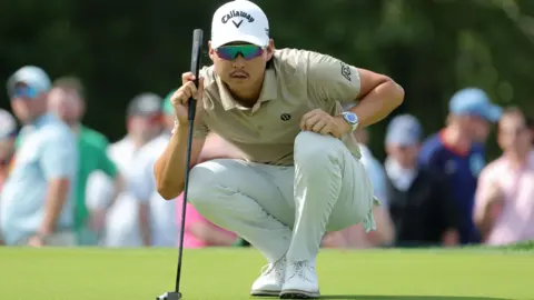 Min Woo Lee studies a putt