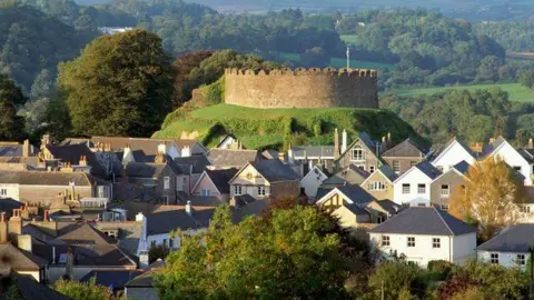 Totnes Castle with its round exterior appears on a hill above the town of Totnes