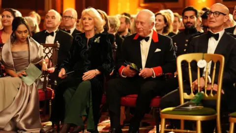 PA Media The King and Queen watching Finding Harmony in the Waterloo Chamber in Windsor Castle