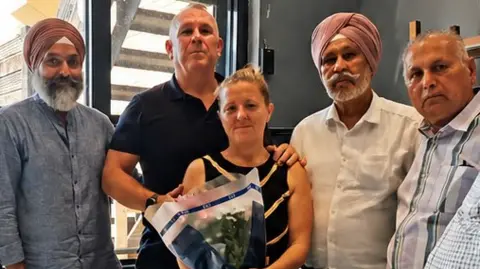 Grays Gurdwara Three members of the Sikh community standing side-by-side with Henry Nowak's mother, Lucy Ross, who is clutching a bouquet of flowers, and her partner, David Stevenson.