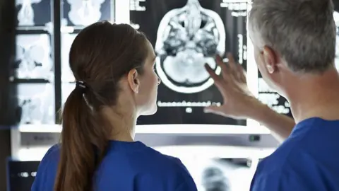 Getty Images Medical staff view a brain scan on a screen