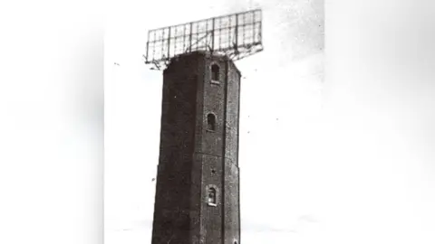 Nye-Browne family The top of the Naze Tower pictured in black and white. The picture was taken during World War Two, with a large radar dish on top of it.