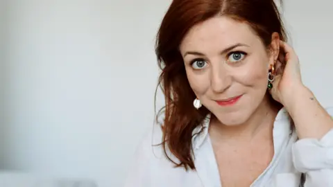 Catriona Byers Catriona Byers has red hair and is wearing a white shirt. She is pictured against a white background.