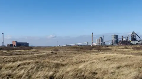 Fields and infrastructure in background on a day with blue skies