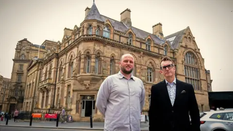 Liberal Democrat cabinet member for culture, communities and youth services Councillor Rob Austin and director of North East Museums Keith Merrin in front of Neville Hall. The 19th Century building has been described by Rob Austin as "magnificent". It is a large structure with three storeys, complete with stained glass windows and carved architectural features.