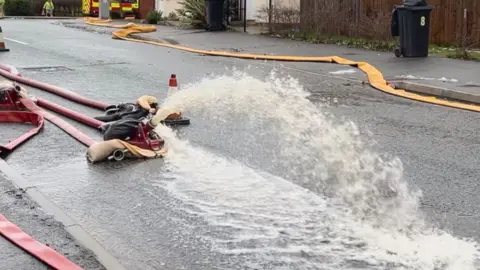 Emergency service pump water away from a culvert and the brook