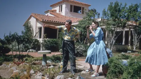 Getty Images American writer and illustrator Dr Seuss (Theodor Seuss Geisel, 1904 - 1991) points towards something in the distance while his wife Helen prepares to take a picture outside their home in La Jolla, California, April 25, 1957.