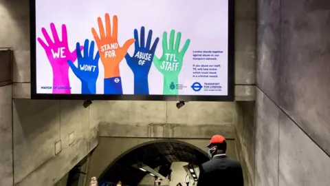 A poster with hands up saying "we won't stand for abuse of TfL staff"