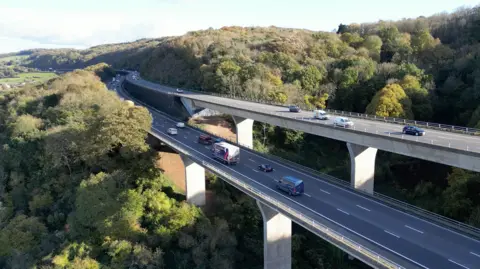 Dan Ayers/BBC The split section of the M5 south of Bristol is seen from a drone. The image is taken in the daytime on a sunny day, and there are cars and lorries on all carriageways