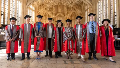 University of Oxford Group picture of nine honorary degree recipients, all in their gowns and caps.