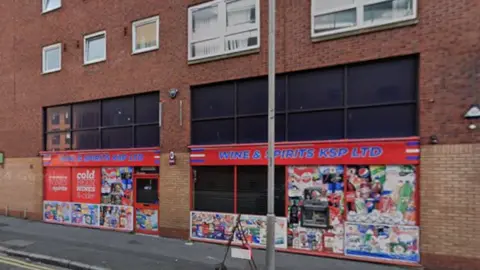Exterior of Wines and Spirits KSP. It has red signage.