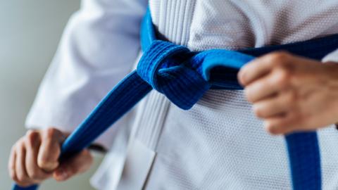 A child tightening a judo belt