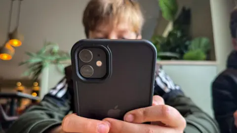 Getty Images A little boy looks at a smartphone 