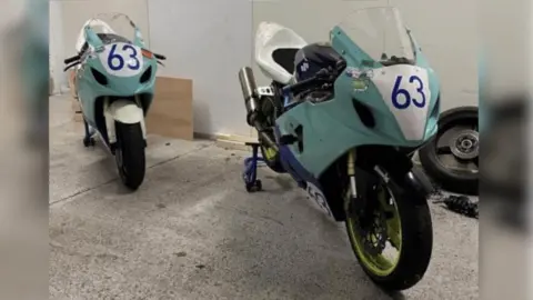 Facebook/Robert Bush Two motorcycles, coloured light blue and white, parked on a concrete floor in what appears to be a garage. Each has the number 63 on the front.