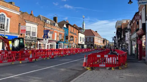 A wide view of The Borough in Farnham, with the pavements sealed off by red plastic rails.