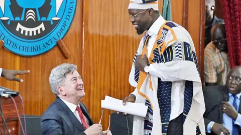 AFP Jean-Luc Mélenchon (L) and Senegalese Prime Minister Ousmane Sonko delivers a speech during a conference at the Cheikh Anta Diop university in Dakar - 16 May 2024