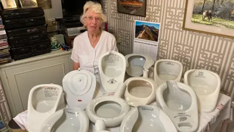 Luke Deal/BBC Mary Jacobs with some of her collection of bedpans