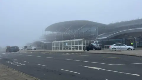 Photo of taxis waiting outside a very foggy Guernsey Airport