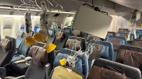 Oxygen masks dangling successful  turbulence-hit Singapore Airlines compartment  