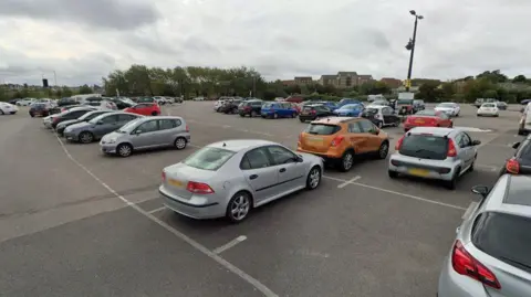 Google A large tarmac car park dotted with parked cars