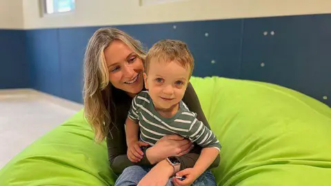 BBC Victoria with her young son Seb both smiling and sitting on a lime green beanbag